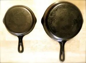 two cast iron skillets one larger