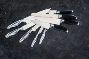 eight knives piled on black table