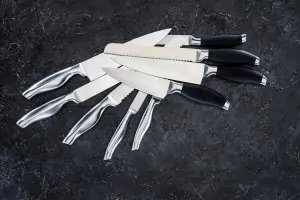 pile of eight knives on black background