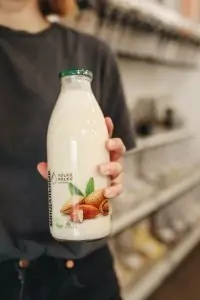 hand holding bottle of almond milk