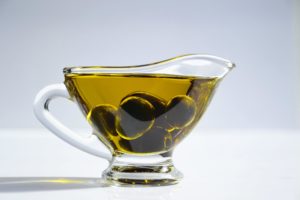 glass cup full of oil and olives