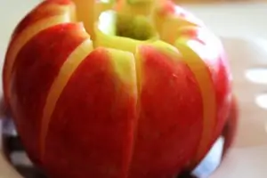 Red apple cored and sliced evenly by apple corer and apple slicer, spread slightly open from the core