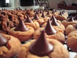 foreshortened lines of peanut butter cookies with chocolate kisses on top spreading into the distance