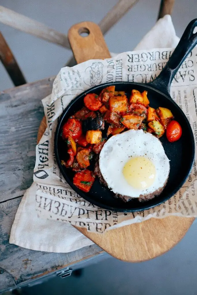 cast iron skillet with an egg and fried potatoes