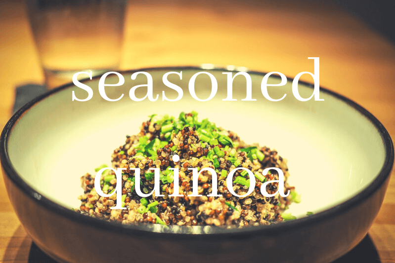 seasoned quinoa in white and brown bowl on wooden table