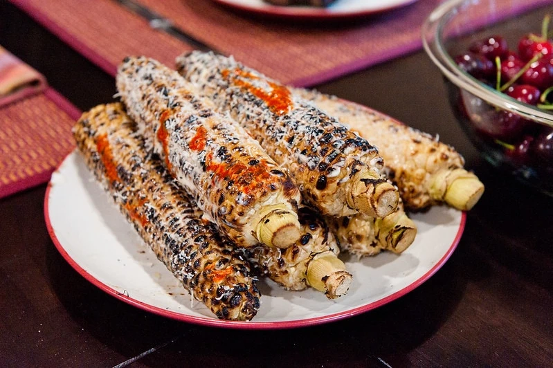 mexican street corn on white plate on table