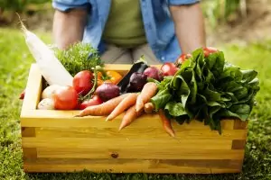 man holding box of fresh produce veggies