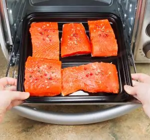 salmon on baking sheet being placed in convection oven