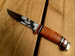 hunting knife with wooden handle on wood table