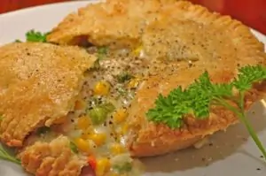 close up of chicken pot pie on white plate with parsley