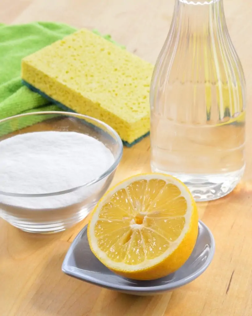 natural cleaning ingredients and sponges on wooden table