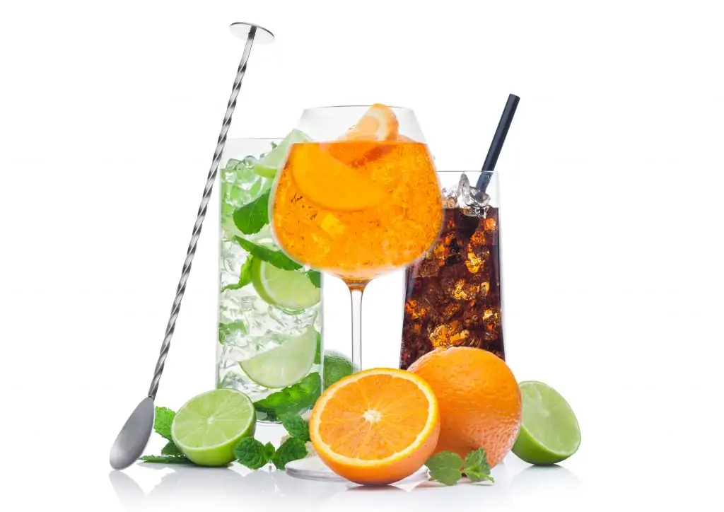 Glasses of Mojito, spritz and cuba libre summer alcoholic cocktail with ice cubes mint and lime on white background. with oranges and raw lime with steel bar spoon
