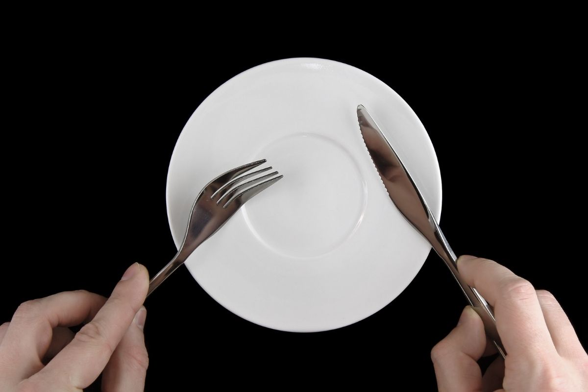 Table serving-knife, fork in hands