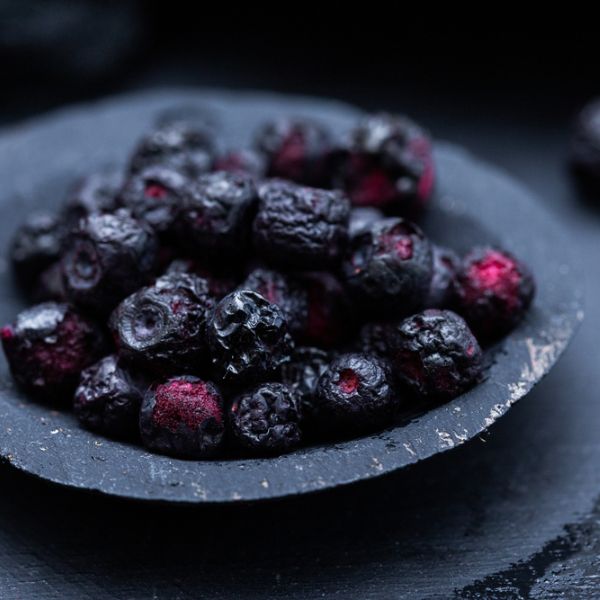 dried blueberries in a small, rustic, black bowl
