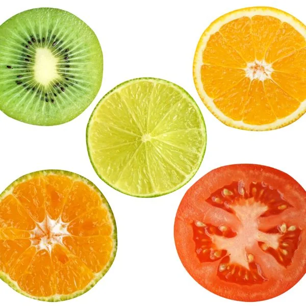 sliced kiwi citrus and a tomato on a white background