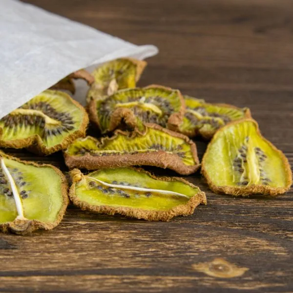 dried kiwi slices pouring out of a paper bag