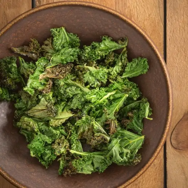 kale chips in a large bowl with sea salt