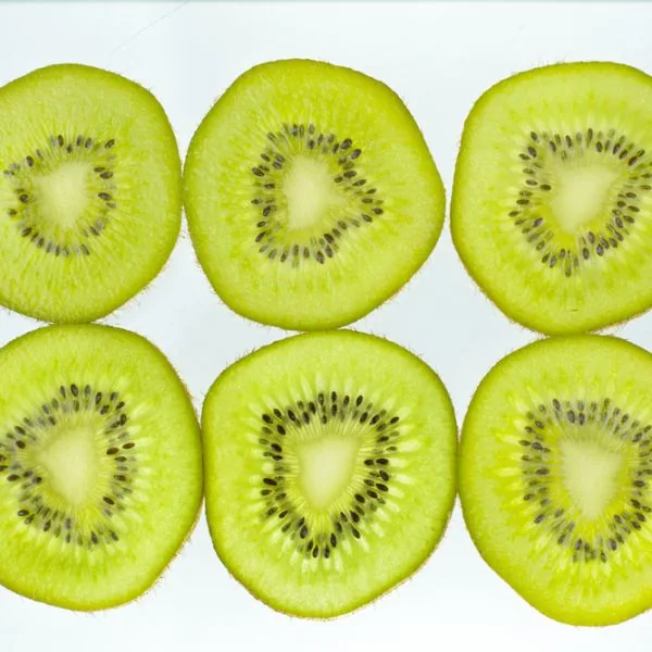 six slices of kiwi on a white background