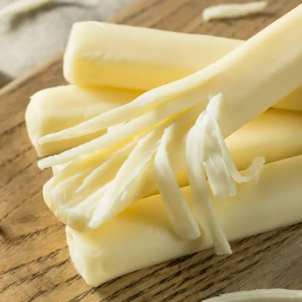 String cheese on a wooden cutting board