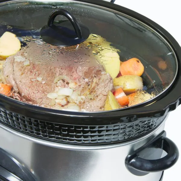 Steak and veggies in a slow cooker with lid on