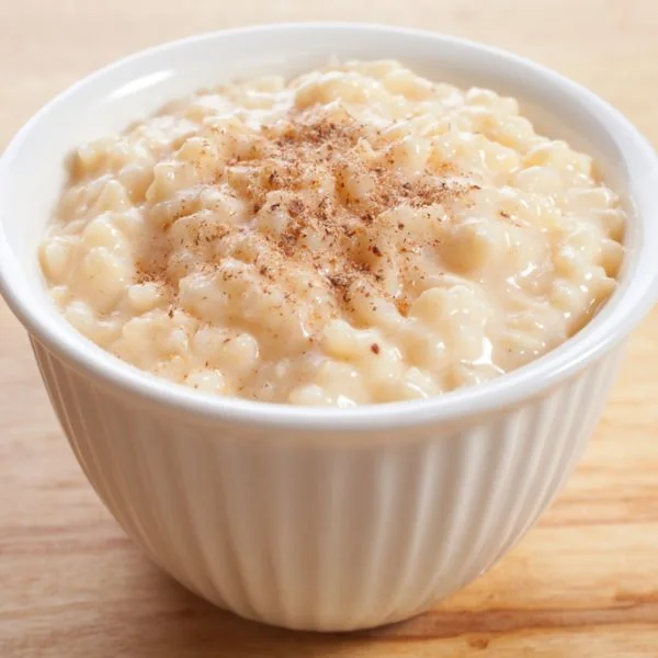 Rice pudding in a white bowl on a wooden background