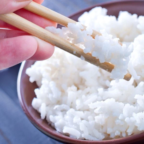 White rice being picked up with chopsticks