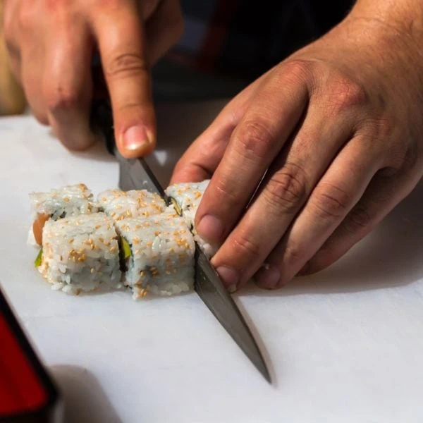 Chef cutting sushi with a sushi knife