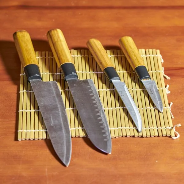 Different sushi knives on a bamboo mat