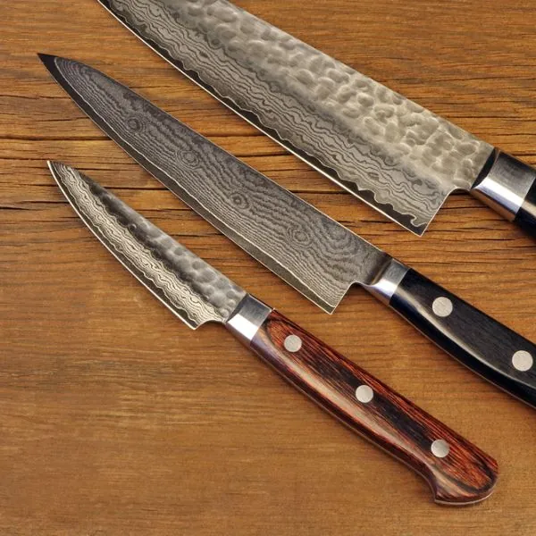 Three Japanese knives on a wooden surface