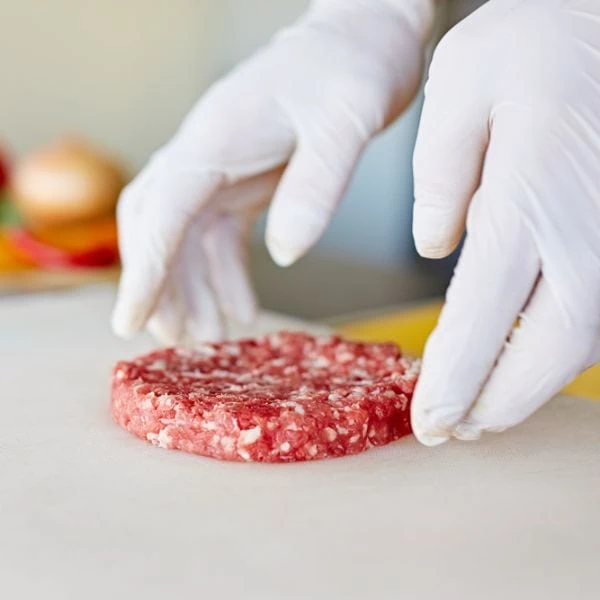 Cook preparing ground meat with latex gloves