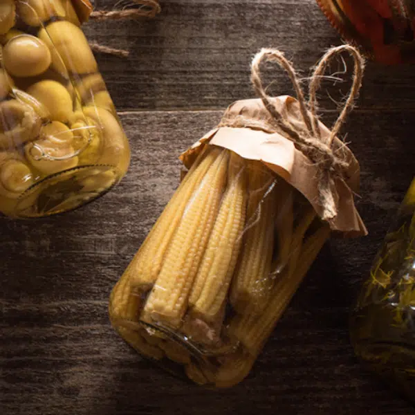 Baby corn picked in a jar among other pickled items
