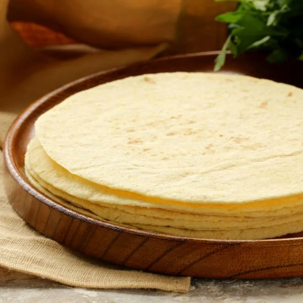 Corn tortillas stacked on a wooden board
