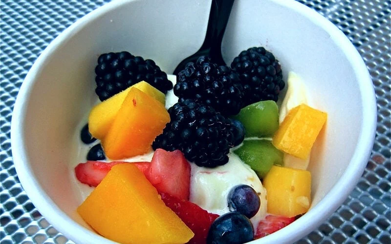Fruit cream in a white bowl with a black spoon