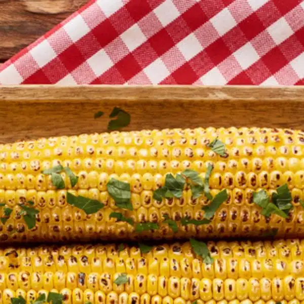 Grilled corn served on a wooden table