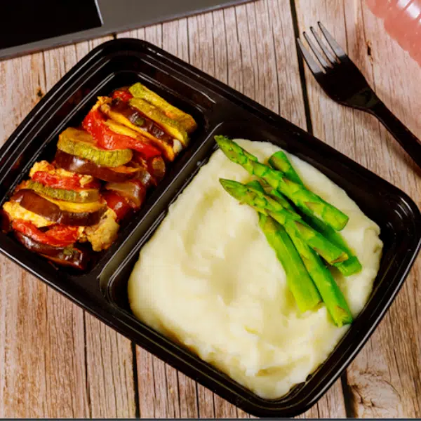 Mashed potatoes in a container with vegetables