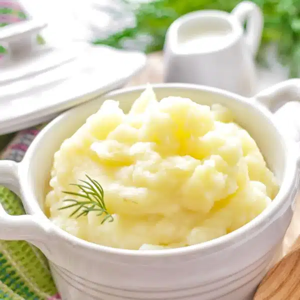 Mashed potatoes in a white lidded bowl