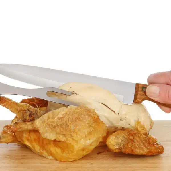 Chicken being carved by someone on a white background