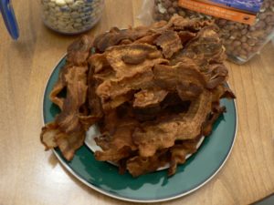 plate of fried bacon on blue plate on wooden table